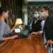 The transformation of travel and hospitality with RPA Couple and receptionist at counter in hotel wearing medical masks as precaution against virus. Couple on a business trip doing check-in at the hotel